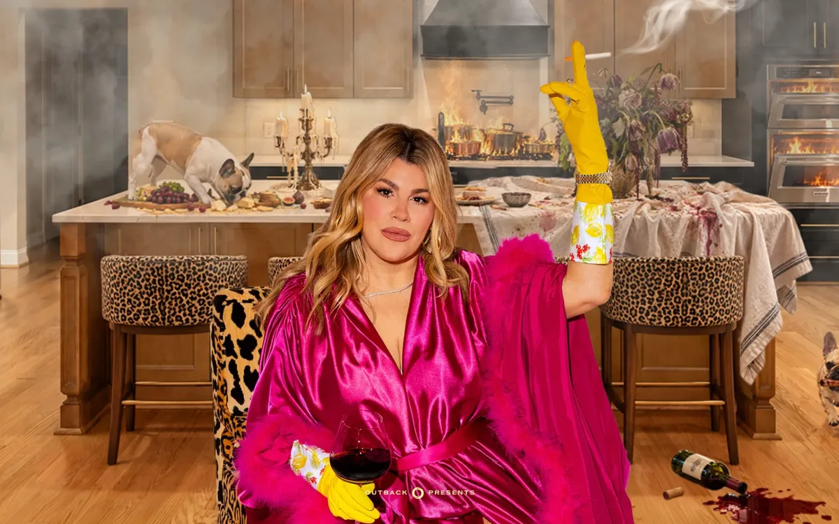 A photo of Heather McMahan wearing a pink robe and holding a lit cigarette in front of a kitchen.
